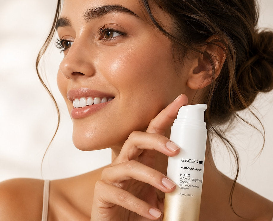 Woman holding Ginger & Me AAA & Brightening Cream beside her face, showcasing a radiant-looking complexion
