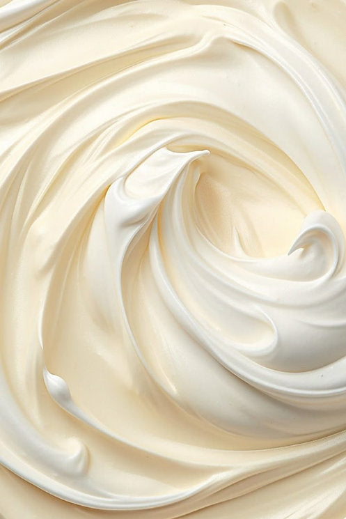 Close-up of rich, creamy body butter texture with soft swirls and a smooth finish.