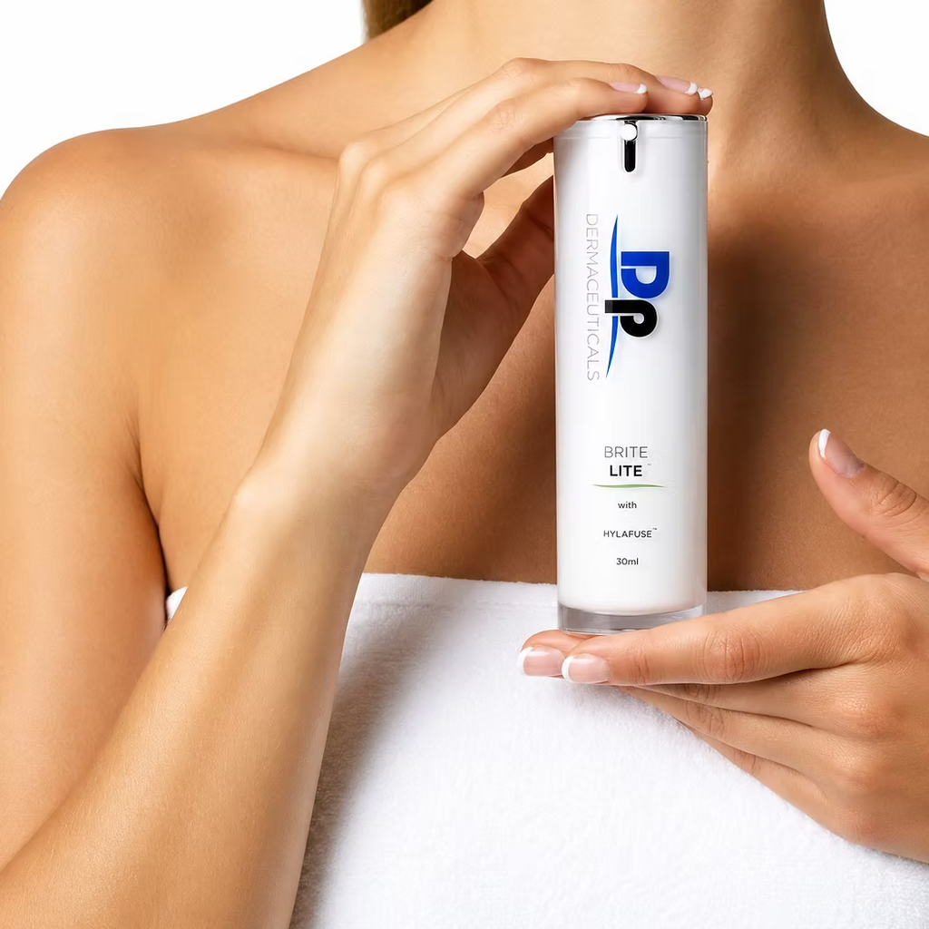 Woman holding DP Dermaceuticals Brite Lite 30ml brightening serum against her chest.