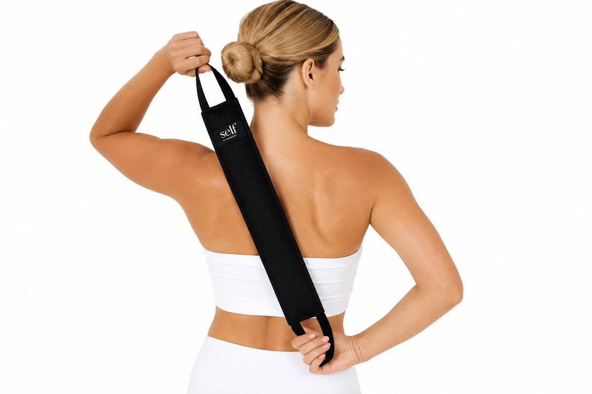 Woman using SELF Tan back applicator to apply self tanner to hard-to-reach areas.