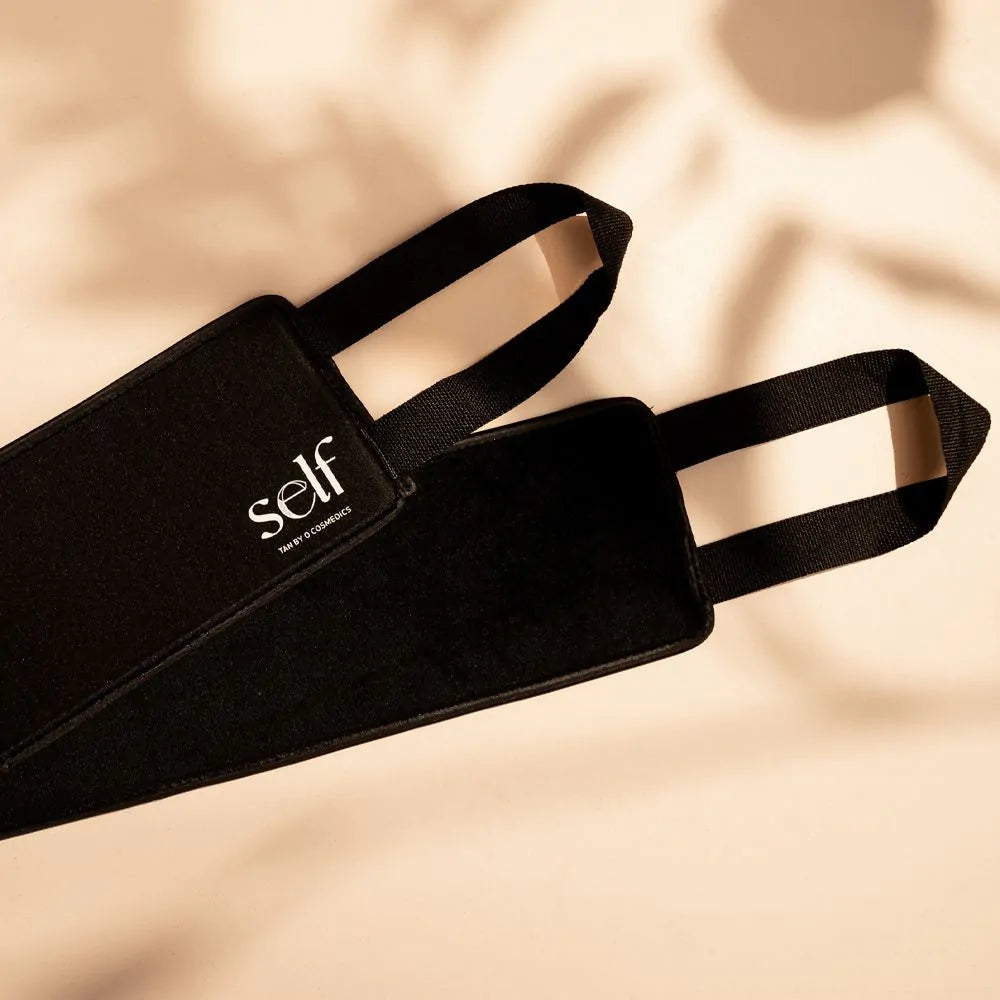 SELF Tan by O Cosmedics velvet back applicator with hand straps on a beige background