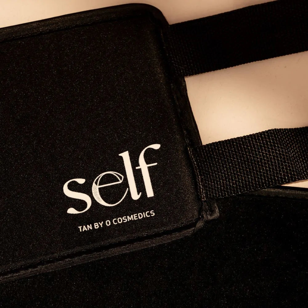 Close-up of SELF Tan by O Cosmedics black velvet applicator fabric and branded label