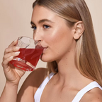 Woman drinking Frank Simple Collagen Beauty Boost pomegranate collagen supplement, formulated with marine and bovine collagen, vitamin C and digestive support ingredients for skin, hair and nail wellness.