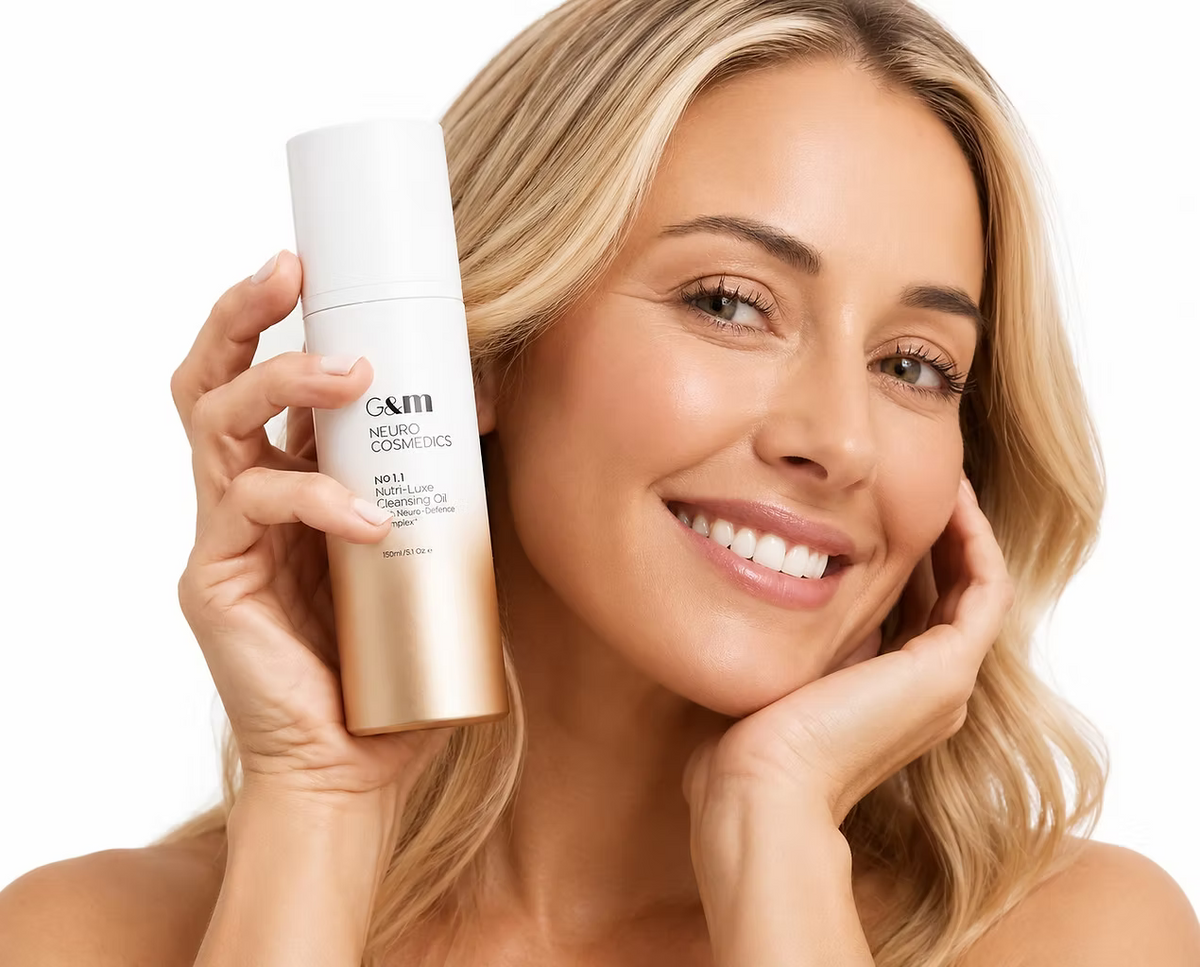 Woman smiling while holding Ginger & Me Nutri-Luxe Cleansing Oil as part of her facial skincare routine.
