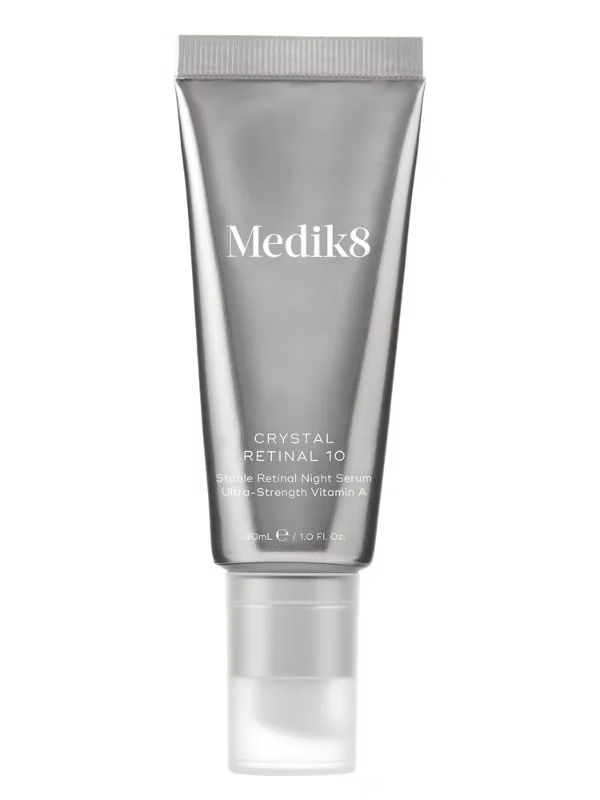 Medik8 Crystal Retinal 10 Night Serum 30ml in silver tube with pump applicator, ultra-strength vitamin A retinal serum on white background.