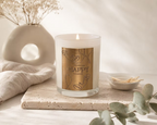 Ginger & Me Happy Scented Candle displayed on a neutral stone surface with soft decorative styling in a bright interior.