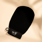 Close-up of black SELF Tan Exfoliating Glove by O Cosmedics showing its rounded shape.