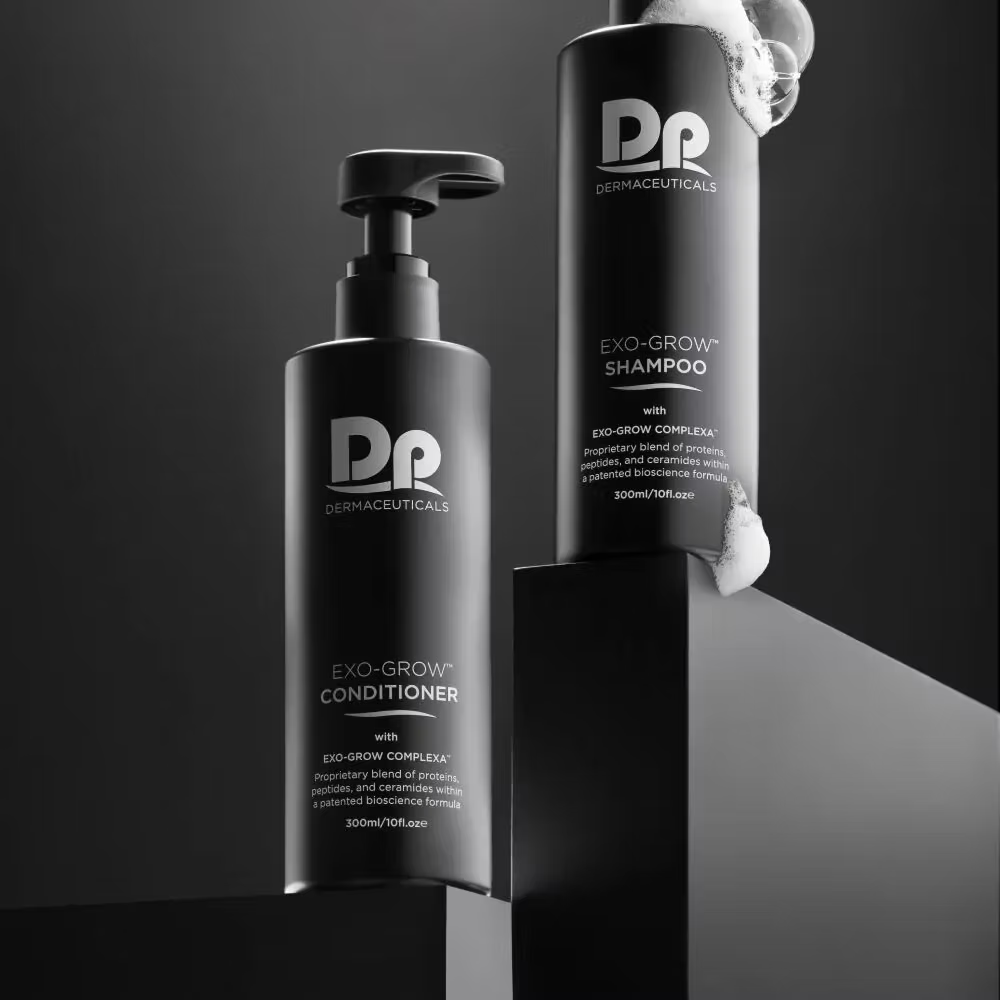 DP Dermaceuticals EXO-GROW Conditioner and Shampoo 300ml bottles displayed together in a premium black studio setting with cleansing foam.