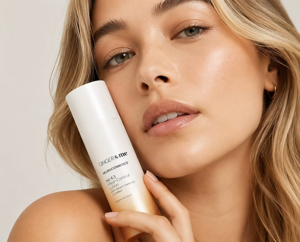 Woman holding Ginger & Me Medi-Control Lotion beside her face, showcasing the 50g facial skincare product.