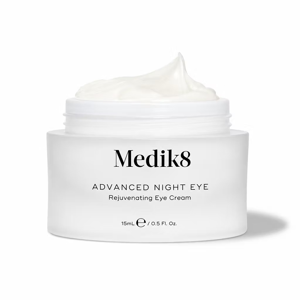 Close-up of Medik8 Advanced Night Eye 15ml rejuvenating eye cream in an open white jar, showcasing its rich, creamy texture against a white background.