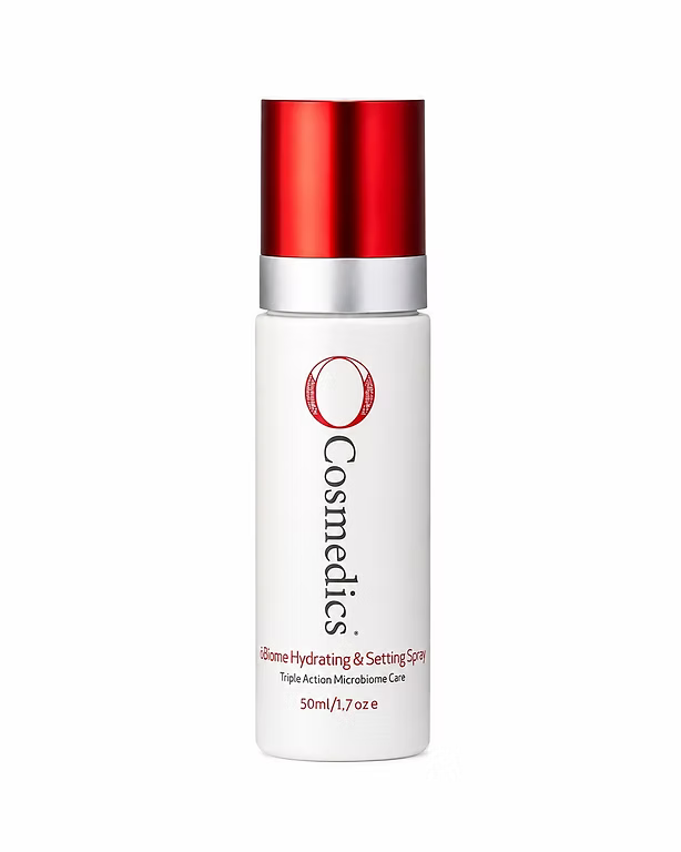 Blonde woman with glowing makeup holding O Cosmedics O-Biome Hydrating & Setting Spray Face Mist 50ml.