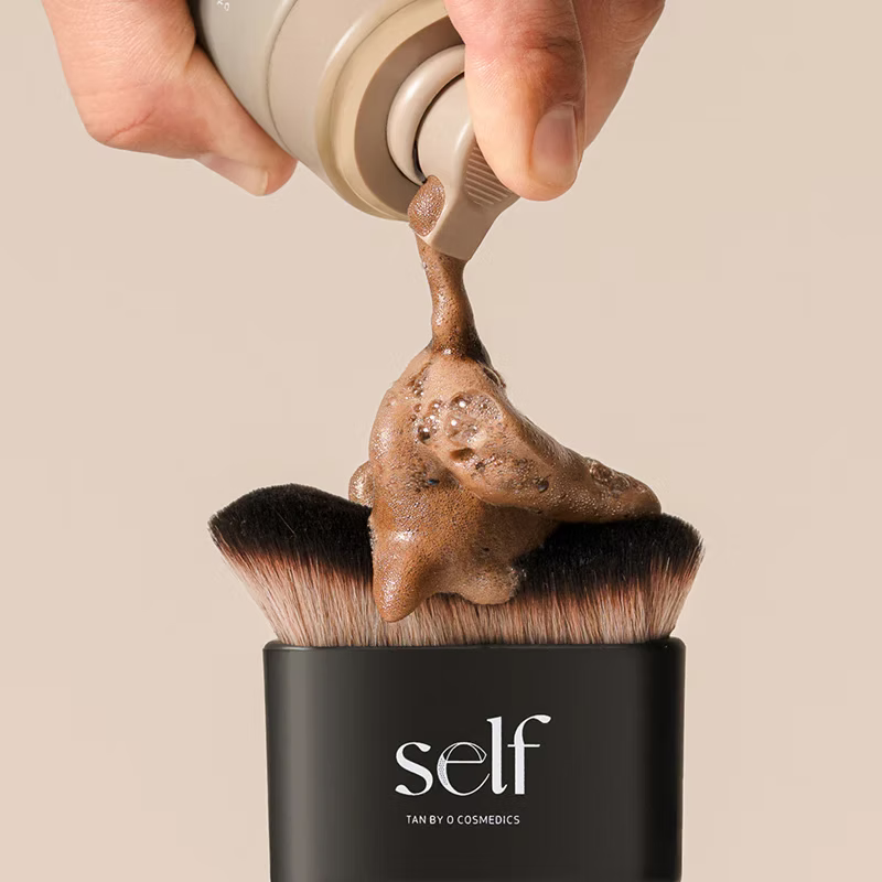 Close-up of self tanning product being applied to the plush bristles of the SELF Tan by O Cosmedics brush.