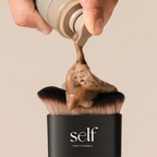 Close-up of self tanning product being applied to the plush bristles of the SELF Tan by O Cosmedics brush.