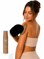 Woman applying self tan to her shoulder using the SELF Tan by O Cosmedics velvet tanning mitt.