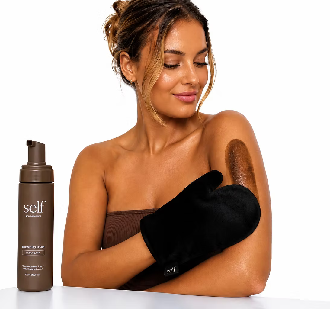 Woman holding a black tanning mitt beside SELF Tan by O Cosmedics Ultra Dark Self Tan Mousse