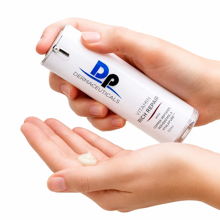 Hands dispensing DP Dermaceuticals Vitamin Rich Repair moisturiser from its 30ml bottle for daily facial skincare.